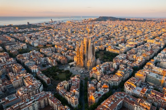 Luftbild des Wohnviertels von Barcelona Eixample und der Basilika Sagrada Familia bei Sonnenaufgang. Katalonien, Spanien. Stadtbild mit typischen achteckigen Blöcken