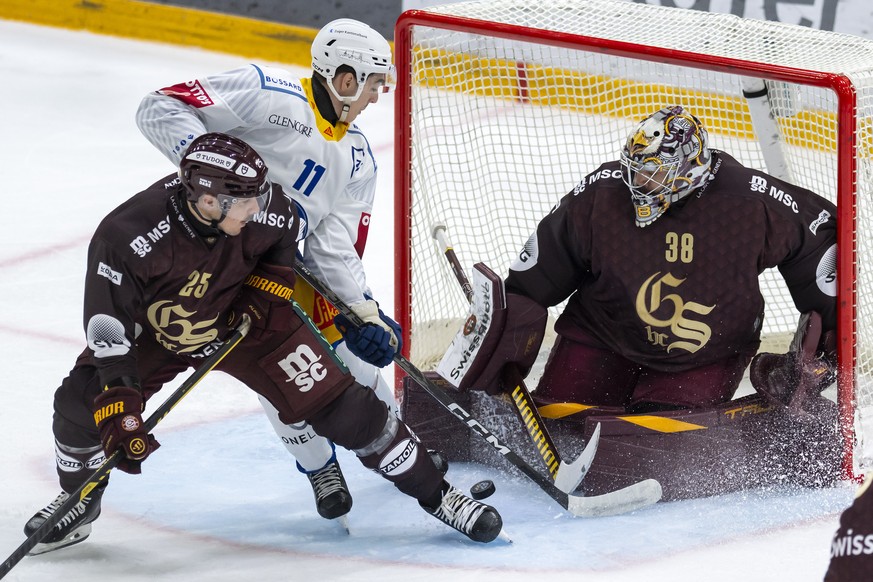 Roger Karrer (GSHC), gauche, lutte pour le puck avec Nik Petrovic (EVZ), centre, devant le gardien Stephane Charlin (GSHC), droite, lors du match du championnat suisse de hockey sur glace de National  ...