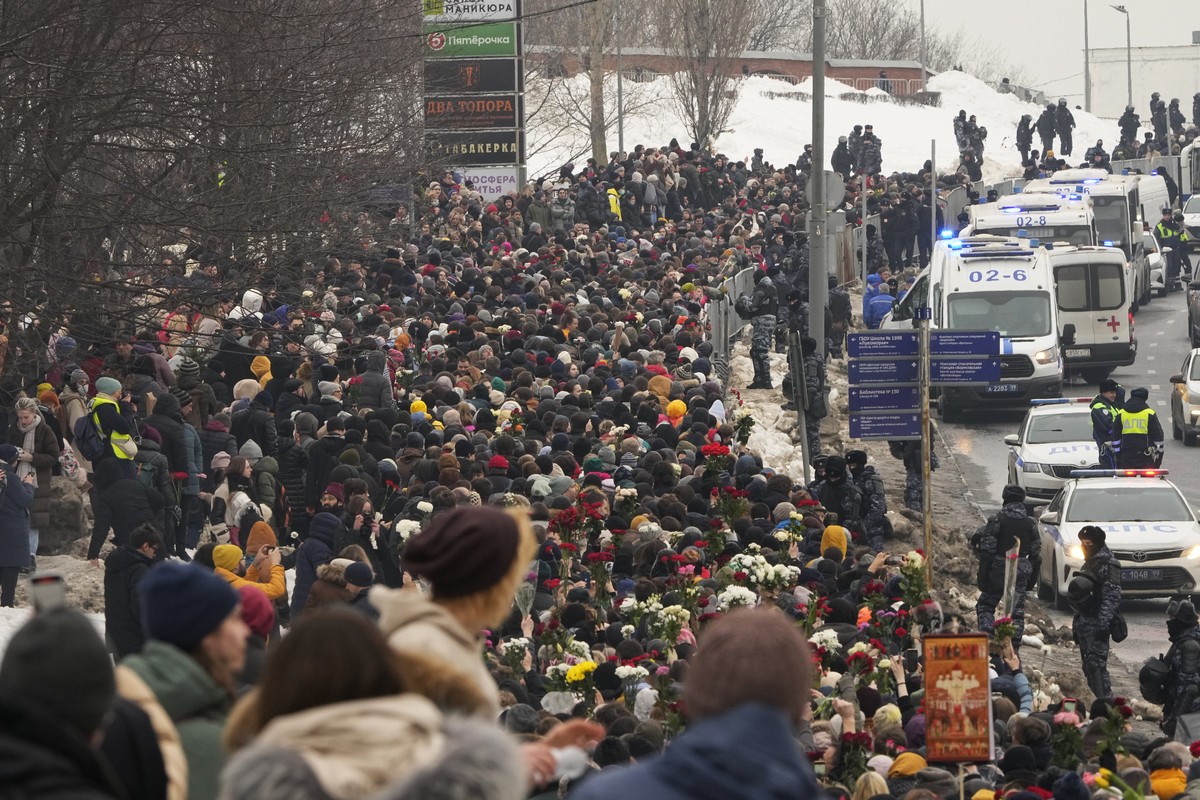 Police, right, observe as people walk towards the Borisovskoye Cemetery for the funeral ceremony of Russian opposition leader Alexei Navalny, in Moscow, Russia, Friday, March 1, 2024. Under a heavy po ...