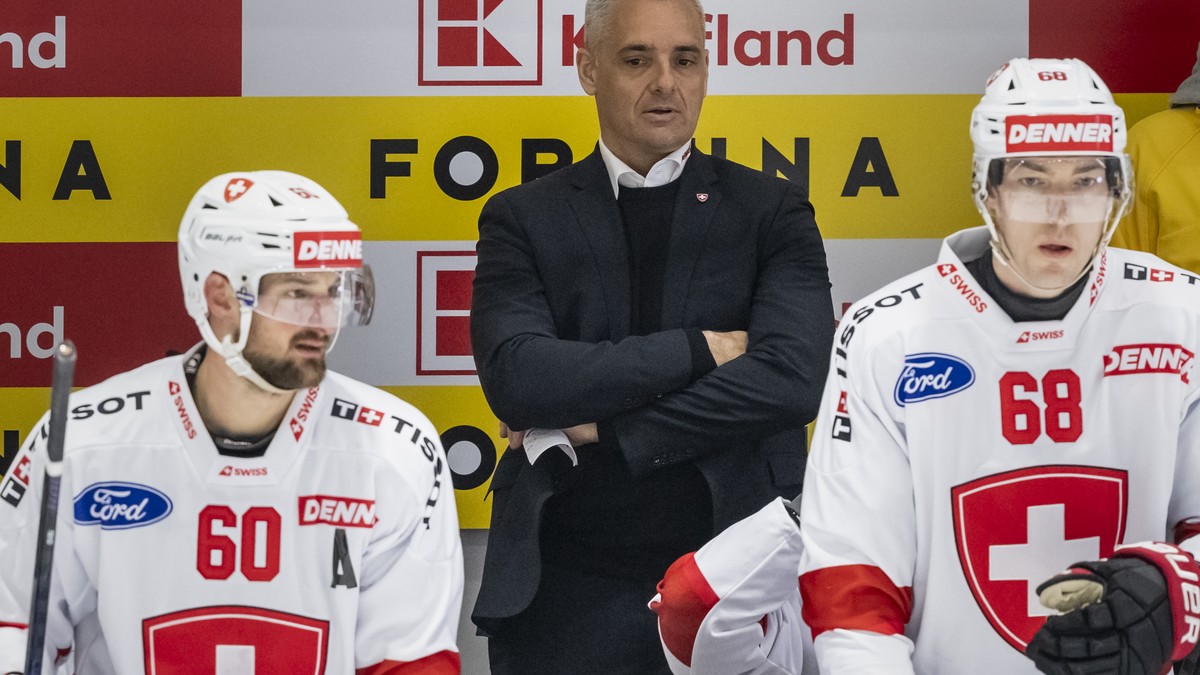 Newly promoted Swiss Head Coach Jan Cadieux, center, instructs his players, Tristan Scherwey, left, and Fabrice Herzog, during his first match as Head Coach of the national team, a friedly ice hockey  ...