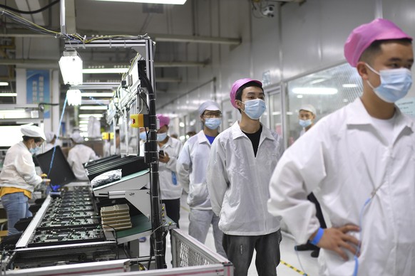 FILE - Workers line up to get tested for COVID-19 at the Foxconn factory in Wuhan in central China&#039;s Hubei province on Aug. 5, 2021. Foxconn, the company that assembles Apple Inc.