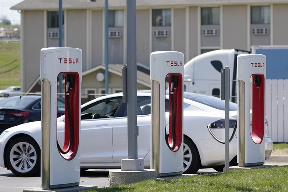 FILE - In this Monday, April 5, 2021 file photo, a Tesla electric vehicle charges at a station in Topeka, Kan. With strong sales of its electric cars and SUVs, Tesla on Monday, April 26, 2021 posted i ...