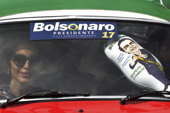 With a campaign sticker and an inflatable doll with the image of right-wing presidential frontrunner Jair Bolsonaro, a supporter drives in her car during a rally in Brasilia, Brazil, Saturday, Oct. 27 ...