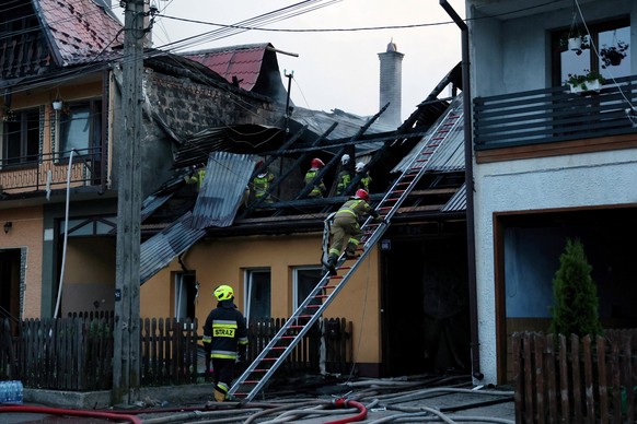 epa09287278 Firefighters work at the scene of a fire in Nowa Biala, south Poland, 19 June 2021. At least nine people were injured in the fire that burnt some 13 residential buildings and 23 farm build ...