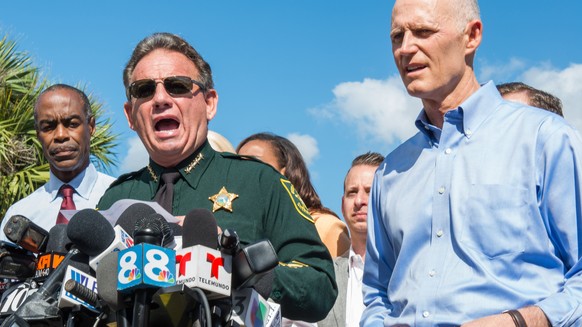 epa06529242 Sheriff Scott J. Israel (L) of Broward County and Governor of Florida Rick Scott (R) speak at a press conference on the outskirts of Marjory Stoneman Douglas High School, Parkland, Florida ...