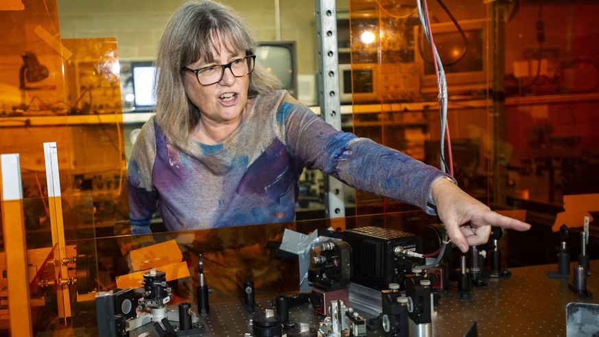 epa07064774 Canadian Donna Strickland, an associate physics professor at the University of Waterloo, demonstrates her laser apparatus after being awarded the 2018 Nobel Prize for Physics, in Waterloo, ...