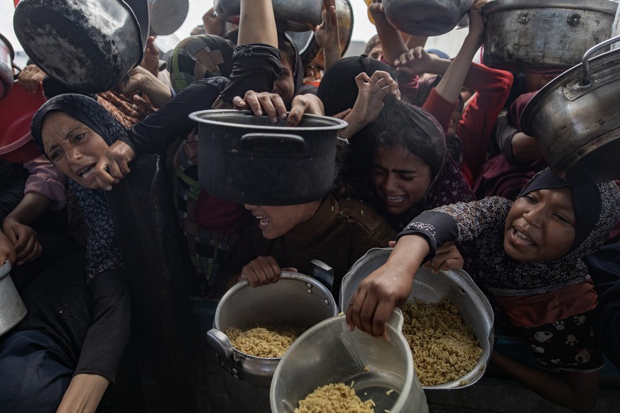 epa12069043 Internally displaced Palestinians push themselves in line to receive a portion of food from a charity kitchen in Khan Yunis, southern Gaza Strip, 02 May 2025. According to the UN Palestini ...