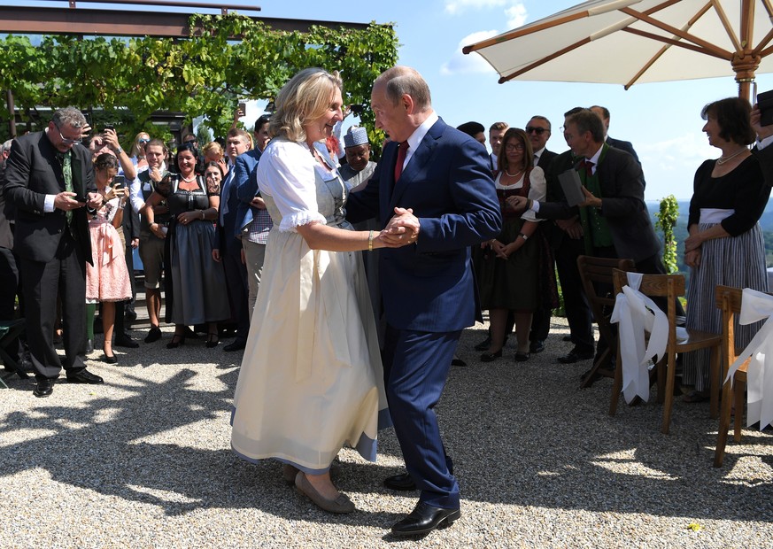 epa06956024 Russian President Vladimir Putin (C-R) dances with Austrian Foreign Minister Karin Kneissl (C-L) during her wedding to Austrian businessman Wolfgang Meilinger in Gamlitz, Austria, 18 Augus ...