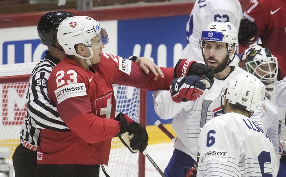 epa09967518 Philipp Kurashev (L) of Switzerland and Valentin Claireaux and Vincent LLorga (R) of France in action during the IIHF Ice Hockey World Championship group A preliminary round match between  ...