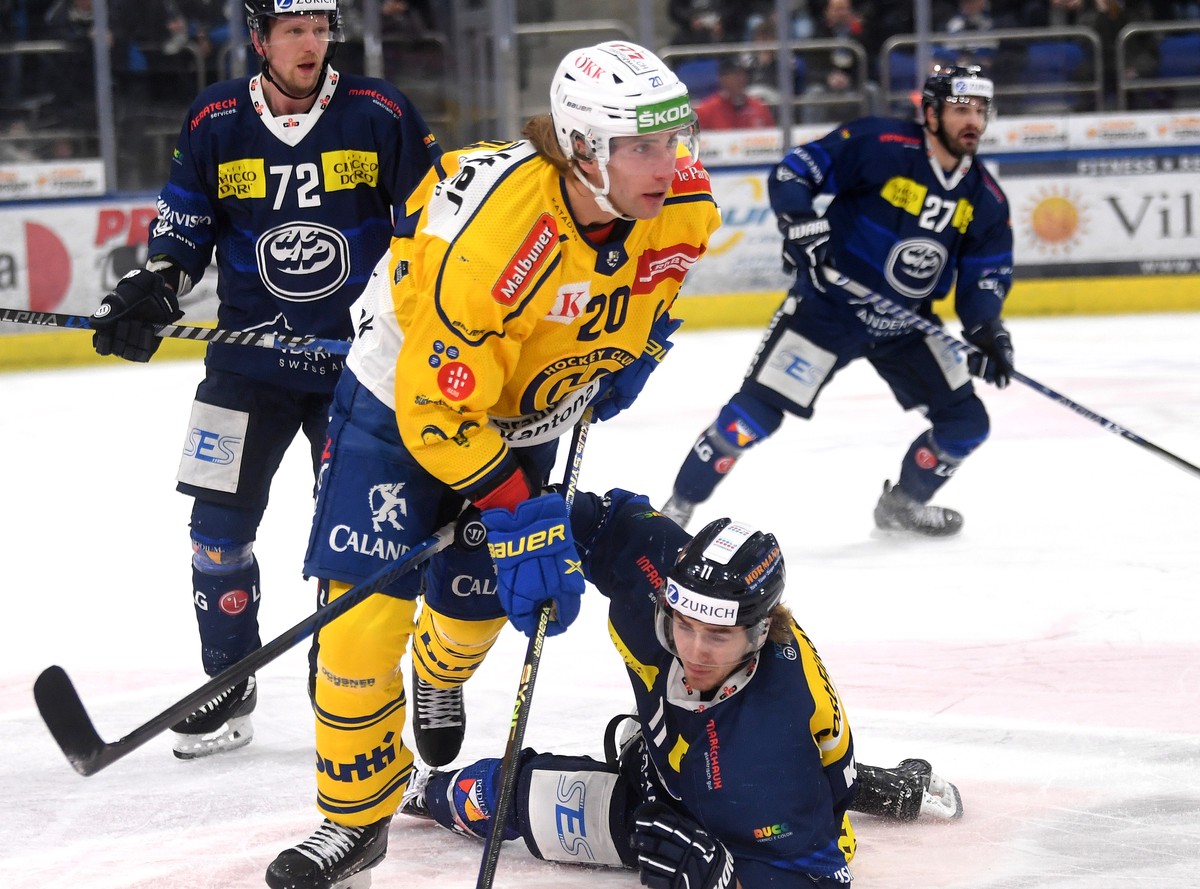 Ambri's player Johnny Kneubuehler, right, fights for the puck with Davos's player Michael Fora left, during the preliminary round game of National League Swiss Championship 2022/23 between,  ...
