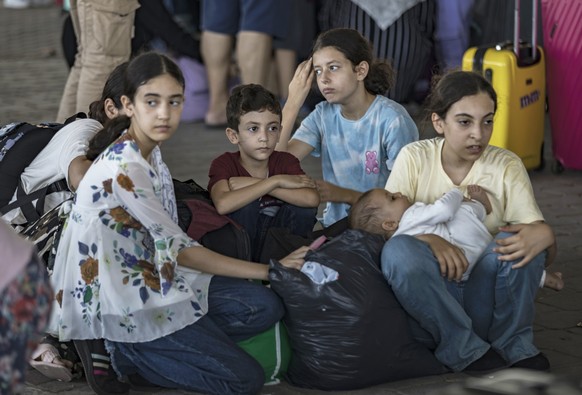 epa10952649 Palestinians wait to cross into Egypt at the Rafah border crossing between the Gaza Strip and Egypt, in Gaza, 01 November 2023. Ambulances carrying evacuees from the Gaza Strip were driven ...