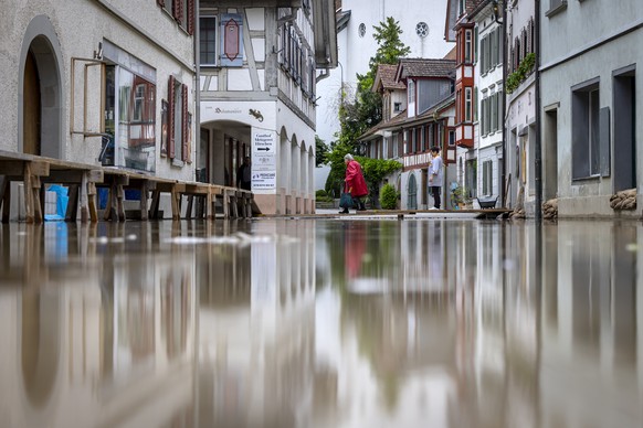 Two women cross a temporary footbridge as the Lake Untersee, the western part of Lake Bodensee overflows its banks, in Berlingen, Switzerland, on Tuesday, June 11, 2024. On Tuesday, the federal govern ...