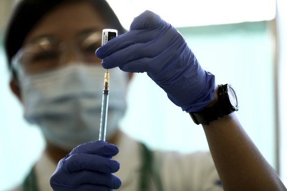FILE - In this Feb. 17, 2021, file photo, a medical worker fills a syringe with a dose of the Pfizer-BioNTech COVID-19 vaccine at Tokyo Medical Center in Tokyo Wednesday, Feb. 17, 2021. Japan's rollout of COVID-19 vaccines began belatedly in mid-February, months behind the United States and many other countries. Officials blamed a shortage of Pfizer Inc. vaccine from Europe as the main culprit in the delay. But three months later, with shipments stabilized and officials attempting to accelerate vaccinations, Japan remains one of the world's least protected. (Behrouz Mehri/Pool Photo via AP, File)