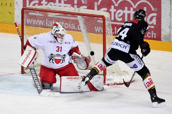 Lugano&#039;s player Jani Lajunen, right, fights for the puck with Lausanne’s goalkeeper Sandro Zurkirchen, left, during the preliminary round game of National League Swiss Championship 2018/19 betwee ...