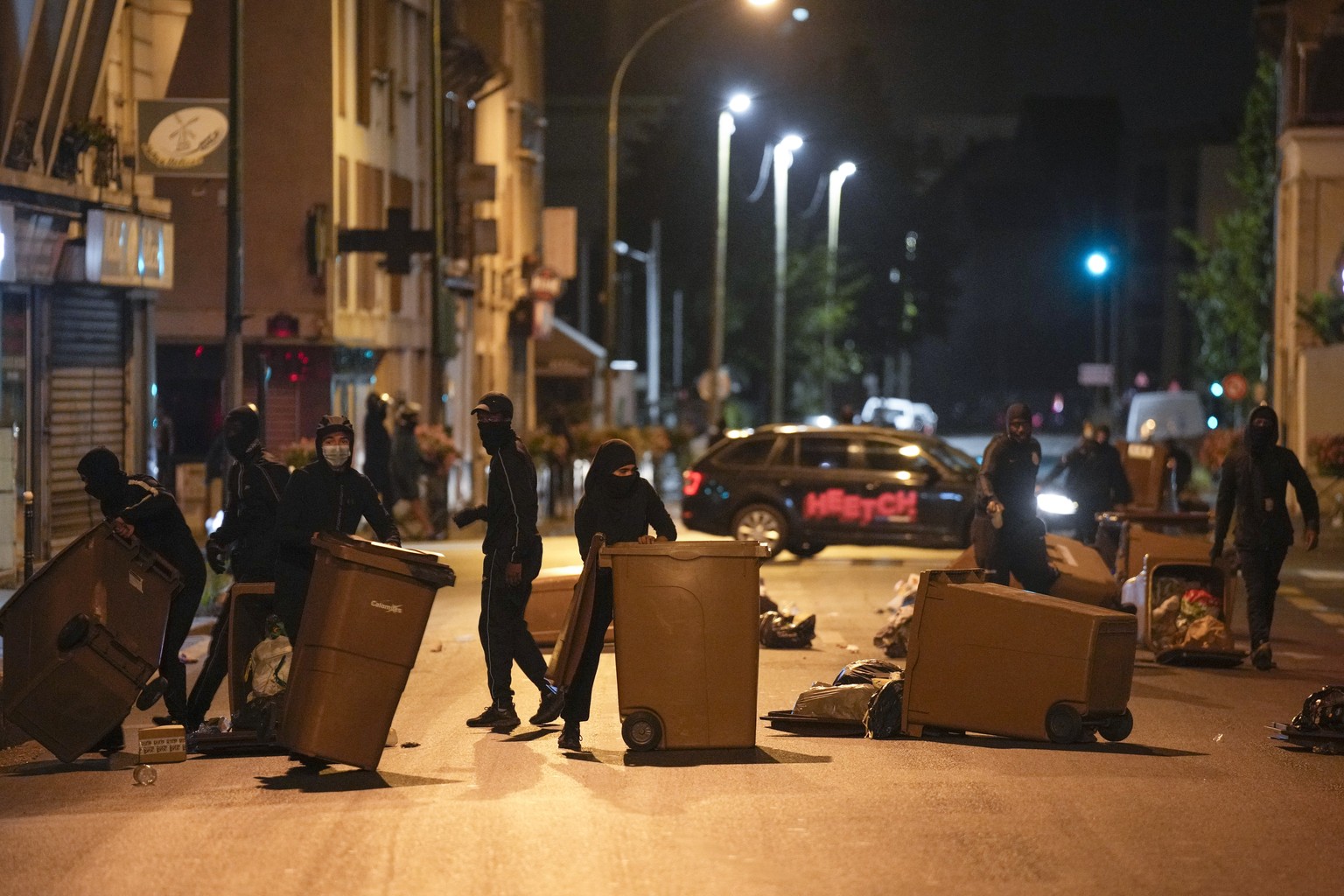 Protesters block a street with garbage cans in Colombes, outside Paris, France, Saturday, July 1, 2023. French President Emmanuel Macron urged parents Friday to keep teenagers at home and proposed res ...