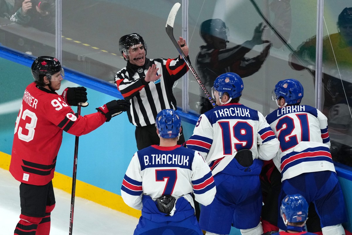 Referee Chris Rooney tries to separate players during a confrontation during the second period of the men's ice hockey gold medal game between the United States and Canada at the 2026 Winter Olym ...