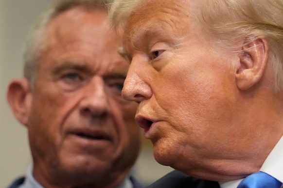 FILE - President Donald Trump speaks in the Roosevelt Room of the White House, Sept. 22, 2025, in Washington, as Health and Human Services Secretary Robert F. Kennedy Jr. listens. (AP Photo/Mark Schie ...