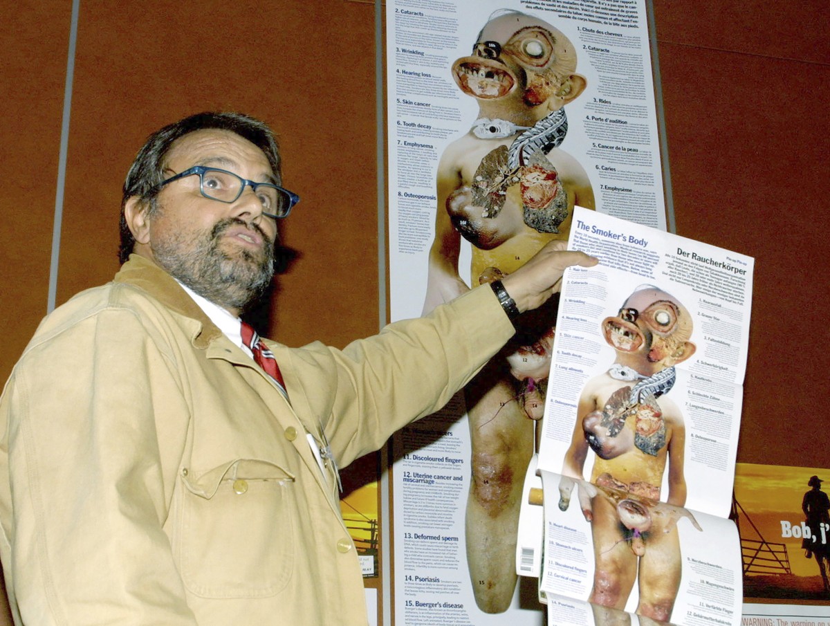 EDS NOTE: NUDITY - File - Italian photographer Oliviero Toscani holds a poster showing a "Smoker's Body" during a press conference on tobacco advertising, in Geneva, Switzerland, Thursd ...