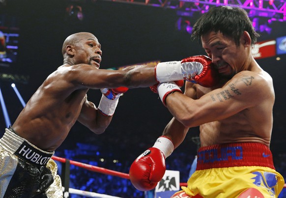 FILE - In this May 2, 2015, file photo, Floyd Mayweather Jr., left, connects with a right to the head of Manny Pacquiao, from the Philippines, during their welterweight title fight in Las Vegas. Maywe ...