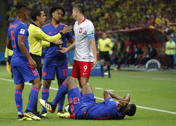 epa06837301 Robert Lewandowski (R) of Poland and Juan Cuadrado (2-R) of Colombia react while Mexican referee Cesar Ramos talks to them during the FIFA World Cup 2018 group H preliminary round soccer m ...