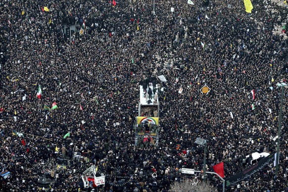 Coffins of Gen. Qassem Soleimani and his comrades who were killed in Iraq by a U.S. drone strike, are carried on a truck surrounded by mourners during a funeral procession, in the city of Mashhad, Ira ...