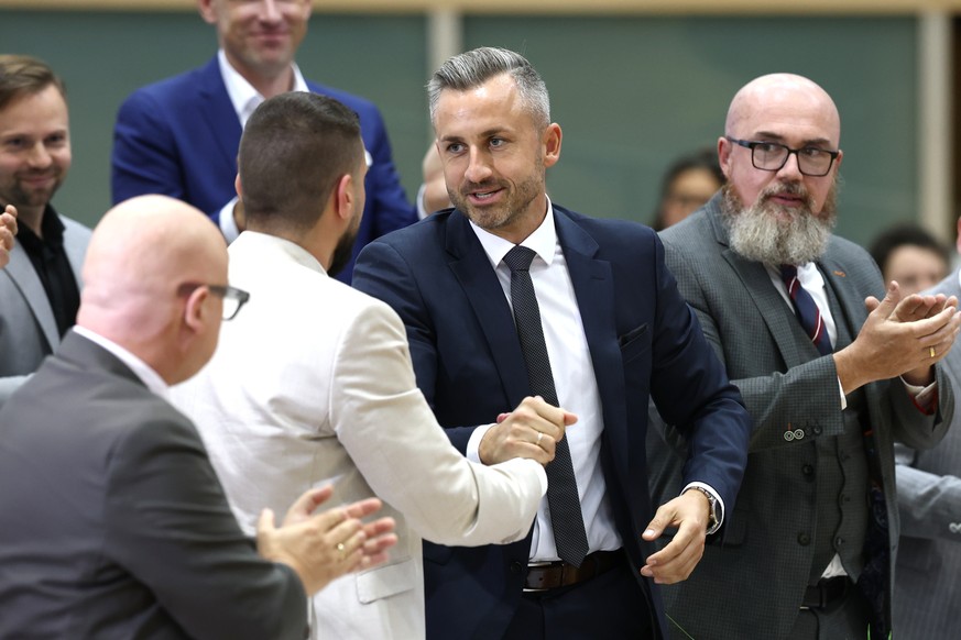 Ulrich Siegmund, center right, and the new elected state parliament president Tobias Rausch, center left, both of the Alternative for Germany (AfD) party, shake hands during the constituent session of ...