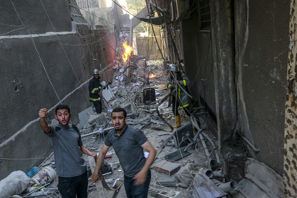epa10107370 Palestinians inspect a destroyed building after Israeli airstrikes in Gaza City, 05 August 2022. According to the Palestinian ministry of health, at least four people were killed, includin ...