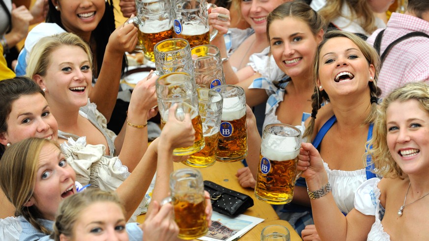 ARCHIV - 18.09.2010, Bayern, Muenchen: Junge Frauen trinken in einem Festzelt auf dem Oktoberfest Bier. (KEYSTONE/picture alliance/dpa)