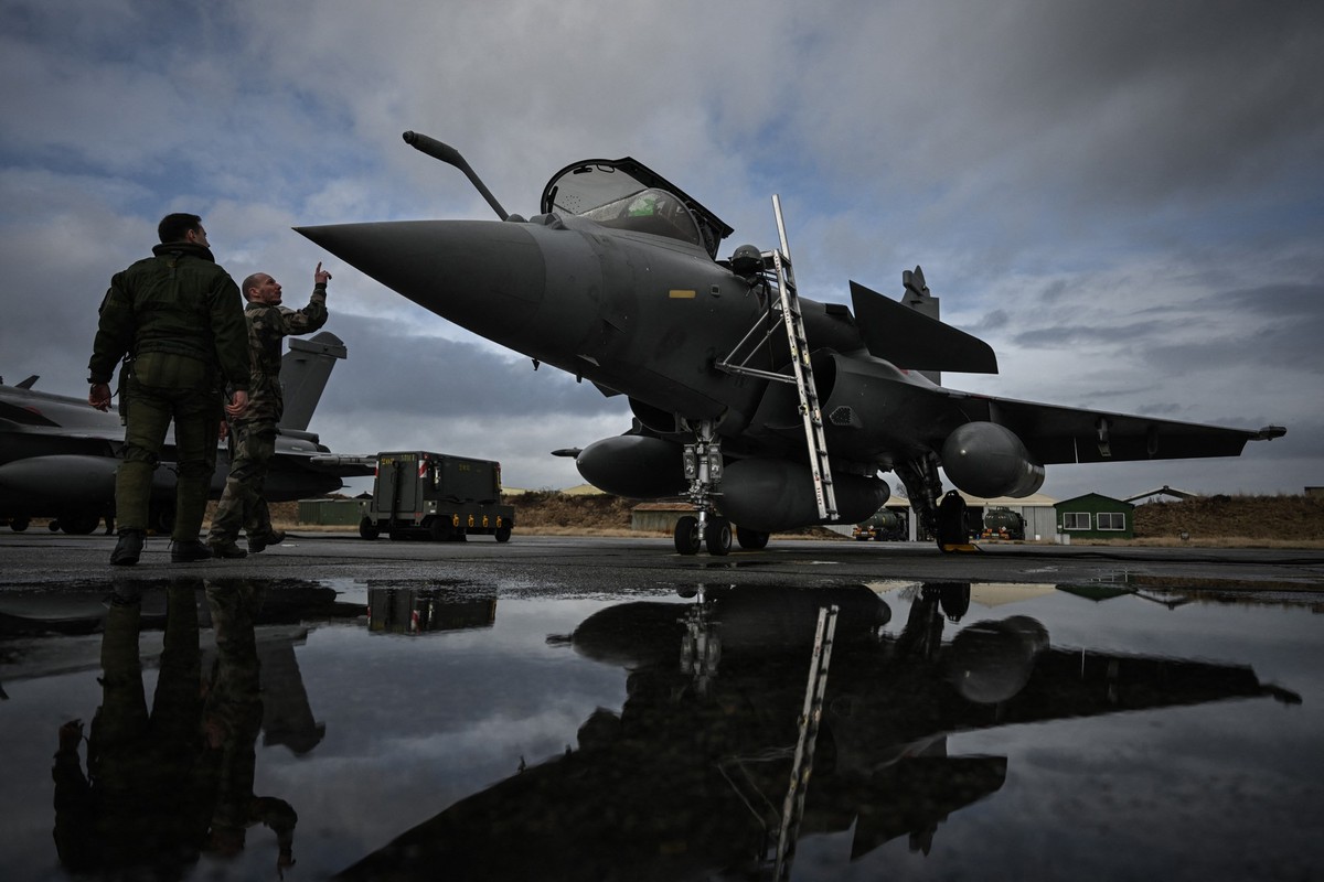 Un pilote français et un militaire inspectent un avion de chasse Rafale à la base aérienne 120 de Cazaux, dans le sud-ouest de la France, le 29 janvier 2026, lors de l'exercice TOPAZE 2026. L ...