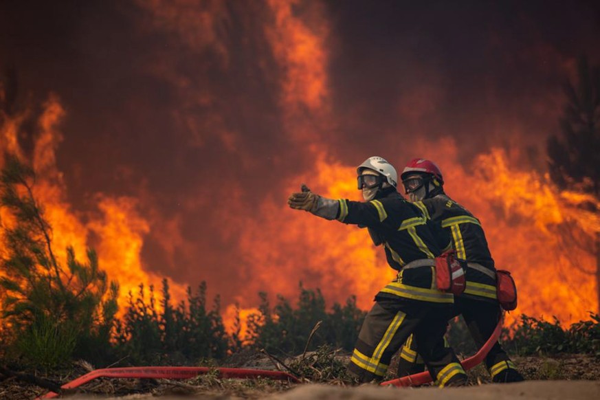 epa10079140 A handout photo made available by the Gironde Fire and Rescue Departmental Service 33 (SDIS 33) shows firefighters battling a forest fire in Landiras, France, 18 July 2022 (issued 19 July  ...