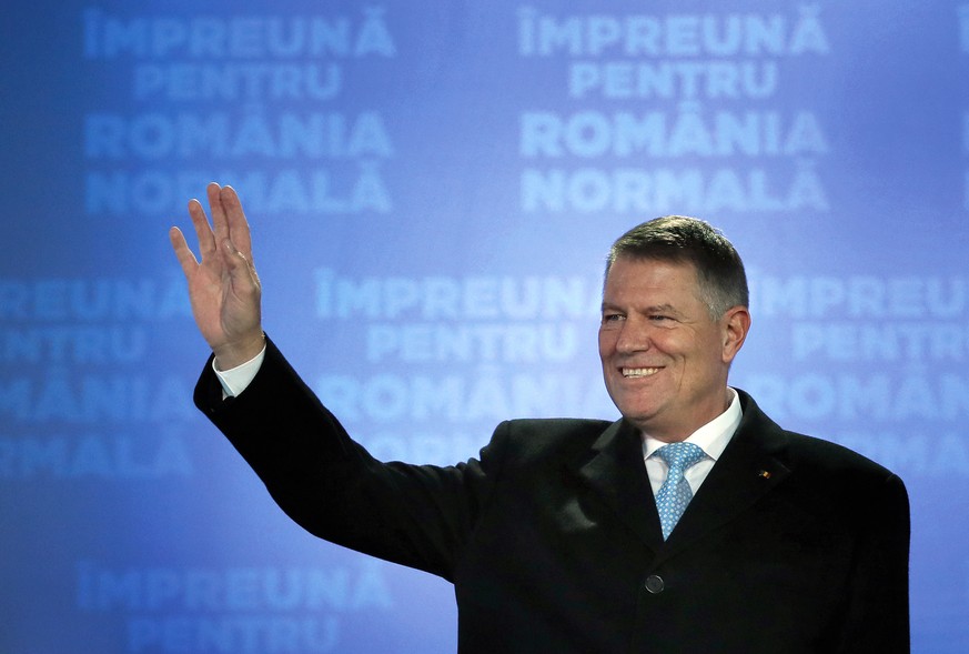 epa08022975 Romanian acting President Klaus Iohannis gestures while addressing the media after first exit-polls results were announced, at the PNL headquarters, during the presidential elections runof ...