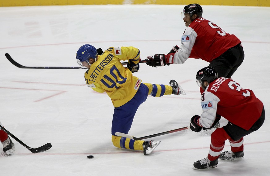 Sweden&#039;s Elias Pettersson, left, checks Austria&#039;s Thomas Raffl and Peter Schneider, right, during the Ice Hockey World Championships group B match between Sweden and Austria at the Ondrej Ne ...