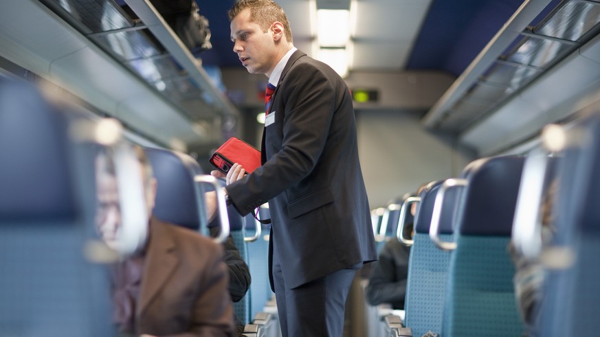 ARCHIVBILD ZUR VERGABE DER FERNVERKEHRSKONZESSIONEN DURCH DAS BAV, AM MONTAG, 23. OKTOBER 2017 - A ticket collector checks the passengers&#039; tickets in an InterCity train of the Swiss Federal Railw ...