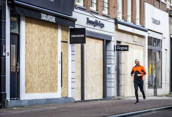 epa08977286 Retailers in the PC Hooftstraat have barricaded their business in Amsterdam, Netherlands, 31 January 2021. The entrepreneurs in the chic shopping street fear damage if riots break out. EPA ...