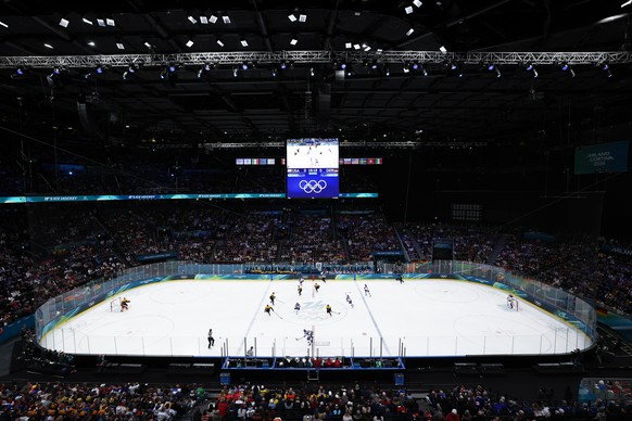 epa12745416 USA players vie for the puck against Germany players during the Men's Preliminary Round match USA against Germany of the Ice Hockey competitions, at the Milano Cortina 2026 Winter Oly ...