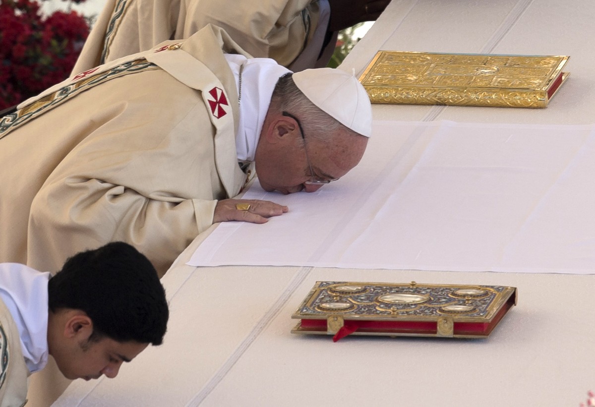 Pope Francis kisses the altar as he arrives to celebrate Easter Mass in St. Peter's Square at the the Vatican, Sunday, April 20, 2014. This year, the Roman Catholic church's celebration of E ...