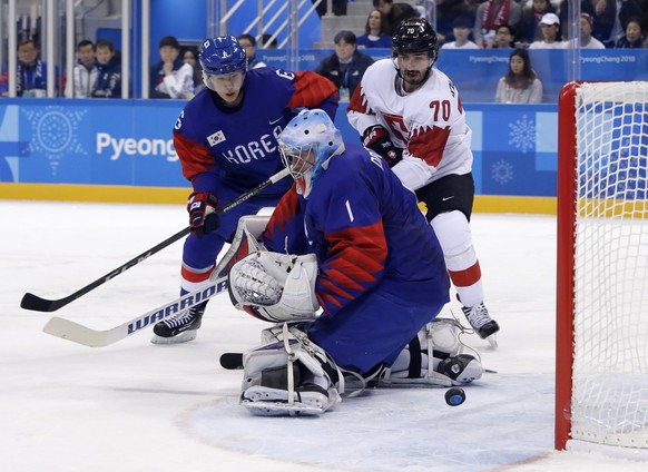 Denis Hollenstein (70), of Switzerland, scores a goal against goalie Matt Dalton (1), of South Korea, during the first period of the preliminary round of the men&#039;s hockey game at the 2018 Winter  ...