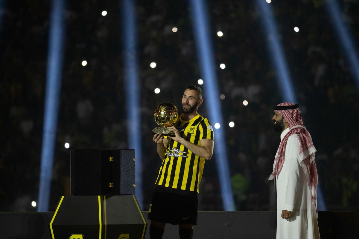 epa10680516 French soccer player Karim Benzema holds the Ballon d'Or trophy he won last year during a presenting event after joining Al Ittihad, in Jeddah, Saudi Arabia, 08 June 2023. Benzema was ...