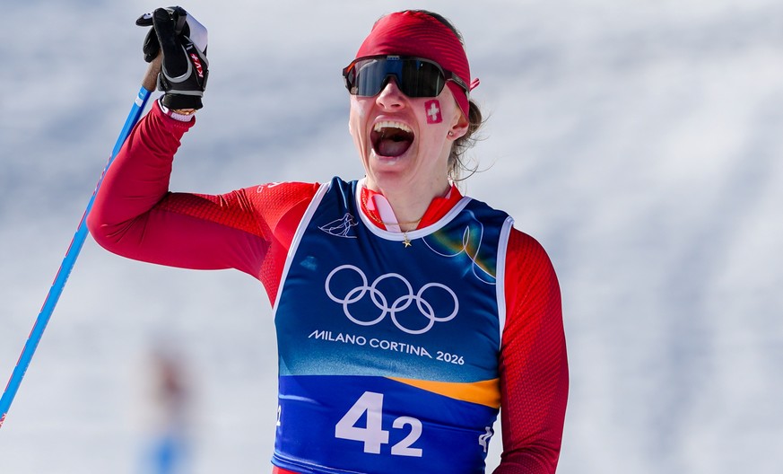 Nadine Faehndrich, of Switzerland, crosses the finish line to win the silver medal in the cross-country skiing women's team sprint free at the 2026 Winter Olympics, in Tesero, Italy, Wednesday, F ...