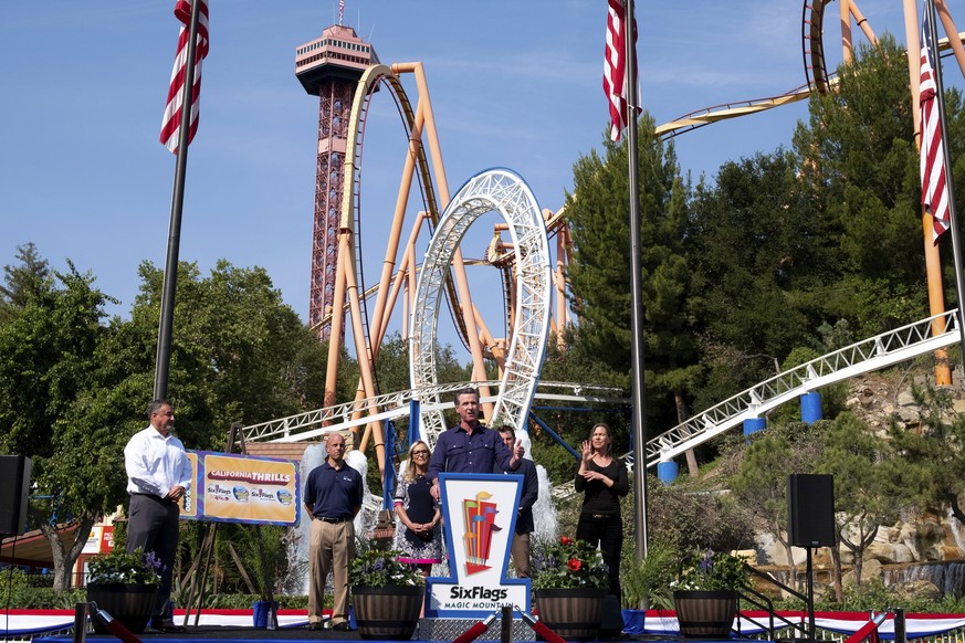 California Governor Gavin Newsom, center, welcomes the public to Six Flags Magic Mountain in Santa Clarita, Calif., on Wednesday, June 16, 2021. In the background are, Don McCoy, from left, President  ...