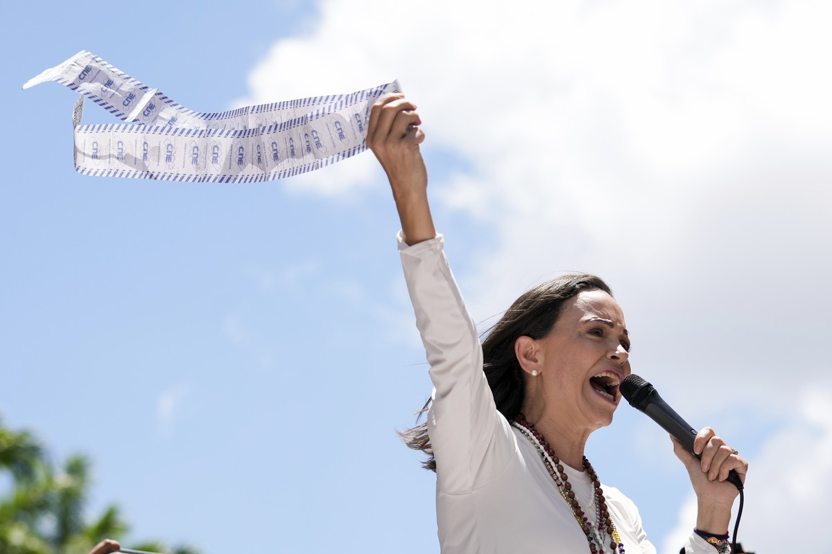 Opposition leader Maria Corina Machado holds up vote tally sheets during a protest against the reelection of President Nicol