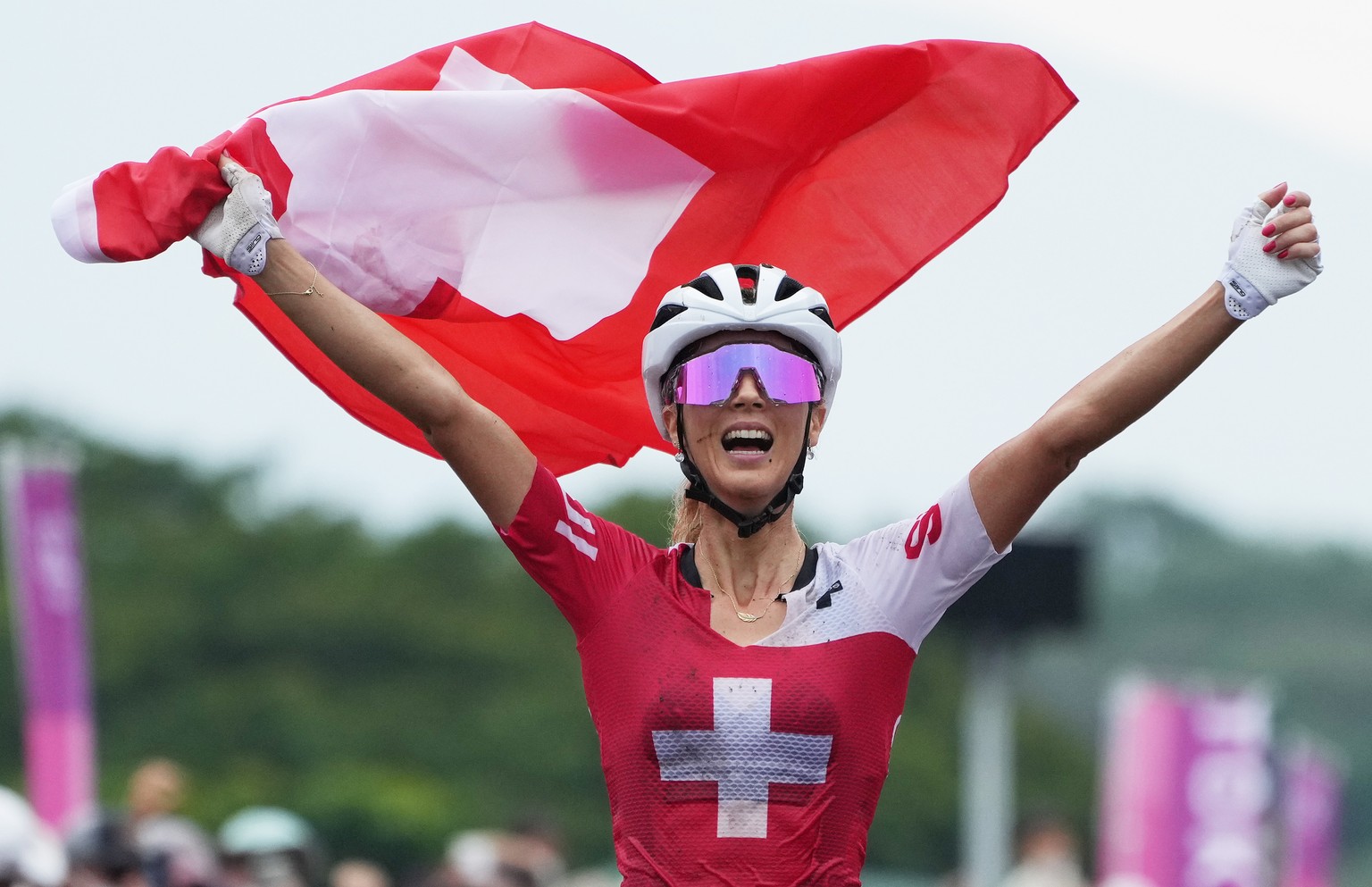 epa09369161 Jolanda Neff of Switzerland celebrates as she is about to cross the finish line winning the Women&#039;s Mountain Bike Cross Country race of the Tokyo 2020 Olympic Games at the Izu Mountai ...