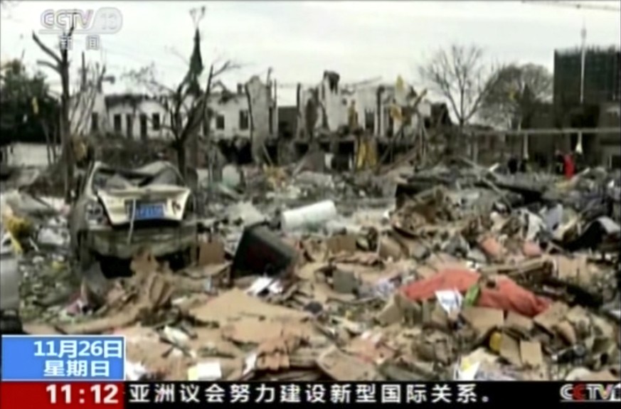 In this image from video run by China&#039;s CCTV, firefighters and people, right, walk near damaged buildings and vehicles following an explosion in Ningbo in east China&#039;s Zhejiang province, Sun ...