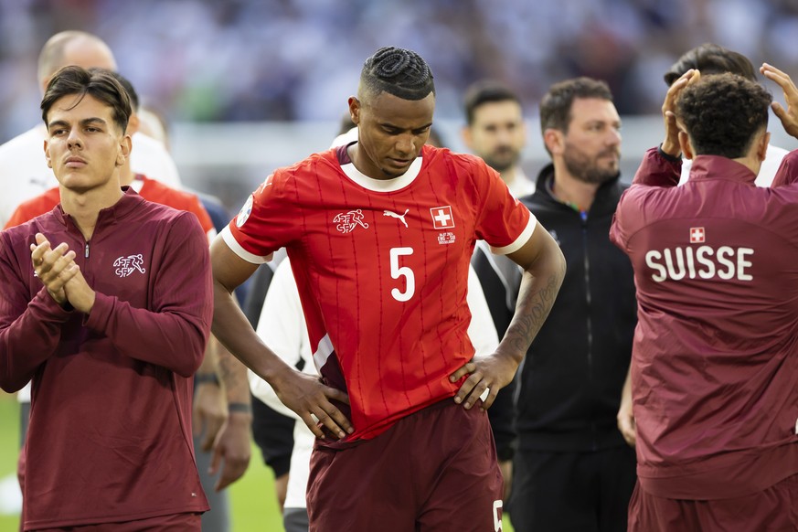 Switzerland&#039;s Manuel Akanji, center, Ardon Jashari, left, and Ruben Vargas, right, react after losing the penalty shoot-out of the quarter final match between England and Switzerland at the Euro  ...