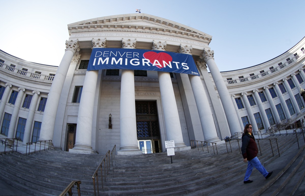FILE - In this Feb. 26, 2018, file photo, a banner to welcome immigrants hangs over the main entrance to the Denver City and County Building. President Donald Trump's executive order threatening  ...