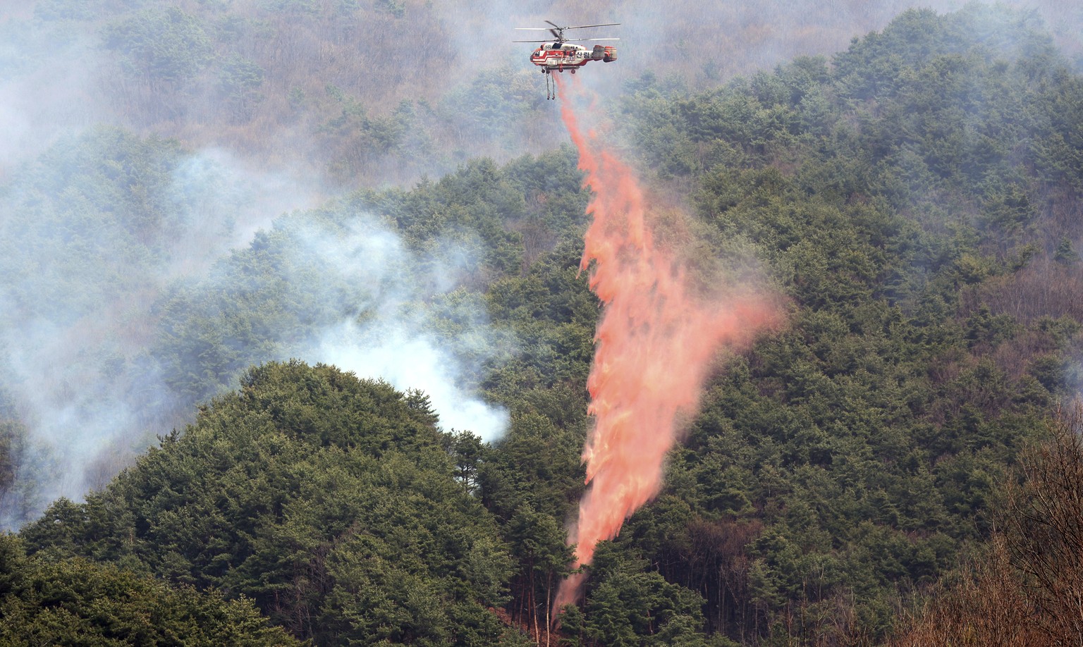 A Korea Forest Service helicopter dumps fire retardant on a wildfire in Sancheong, South Korea, Tuesday, March 25, 2025. (Kim Dong-min/Yonhap via AP)
South Korea Wildfires