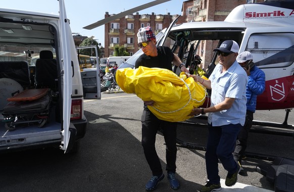 Jim Morrison carries the body of his partner and famed U.S. extreme skier, Hilaree Nelson, from a helicopter at a hospital in Kathmandu, Nepal, Wednesday, Sept. 28, 2022. Nelson, 49, was skiing down f ...