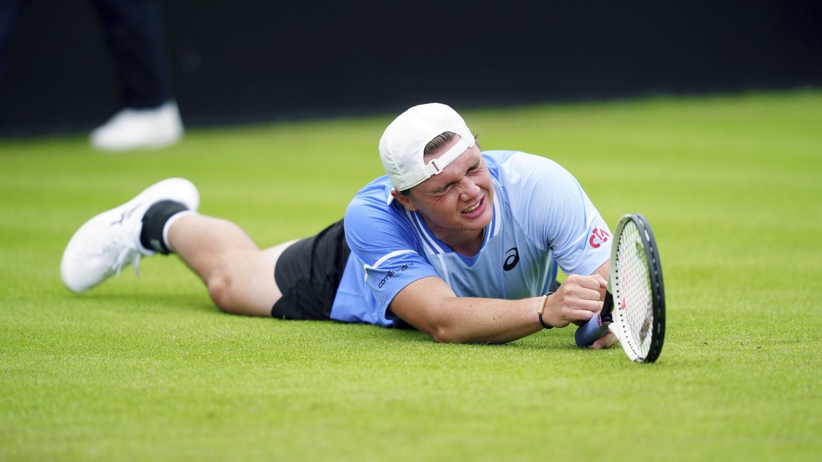 CORRECTS NATIONALITY Switzerland's Dominic Stricker appears injured during his men's singles match against Britain's Daniel Evans on day two of the Rothesay Open at the Lexus Nottingham ...