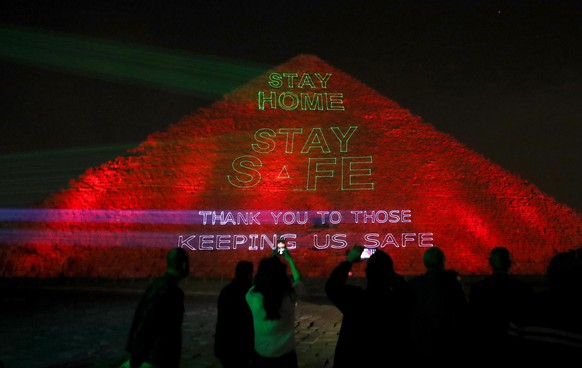 epaselect epa08332931 General view of the pyramids lit up with text encouraging Egyptians to stay home and safe because of  COVID-19 and sending a thank you massage to those keeping poeple safe  in Giza, Egypt, 30 March 2020. Egyptian authorities had announce a two-week curfew, which started on 25 March, during which public transportation will be suspended to avoid the spread of the SARS-CoV-2 coronavirus which causes the COVID-19 disease.  EPA/KHALED ELFIQI