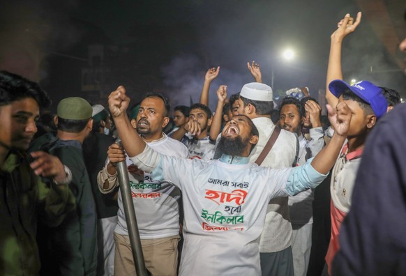 epa12602002 Protesters shout slogans at the Shahbagh intersection in Dhaka, Bangladesh, early 19 December 2025. Demonstrations broke out after Inqilab Mancha spokesperson Sharif Osman Hadi died while  ...